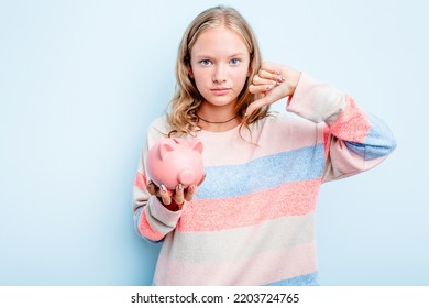 Caucasian Teen Girl Holding A Piggybank Isolated On Blue Background Showing A Dislike Gesture, Thumbs Down. Disagreement Concept.