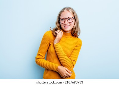 Caucasian Teen Girl Isolated On Blue Background Confused, Feels Doubtful And Unsure.