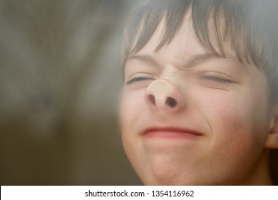 Caucasian Teenage Boy Pressing His Nose Against A Window