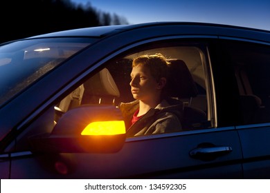 Caucasian Teenage Boy Sitting in Car at Night