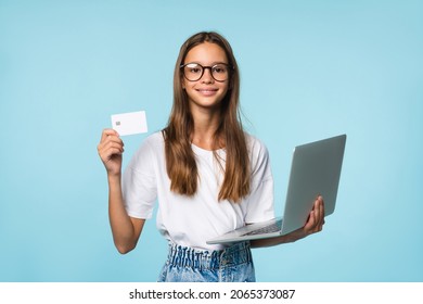 Caucasian teenager girl student pupil using laptop computer for paying online with credit card, shopping from home, e-banking isolated in blue background