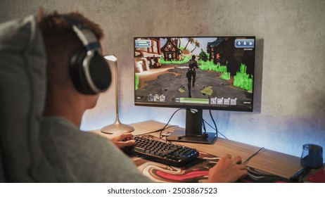 Caucasian teenager wearing headphones plays online video game on PC, spends leisure time at home. Professional young gamer enjoys gameplay in 3D third person shooter on computer. Gaming and Esports. - Powered by Shutterstock