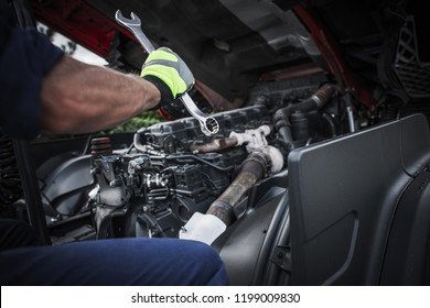 Caucasian Truck Mechanic Repairing Semi Truck Engine.