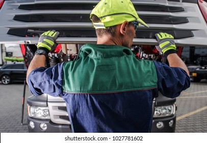 Caucasian Truck Service Worker Opening Semi Truck Hood And Preparing For Scheduled Maintenance.