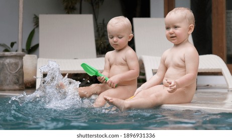 Caucasian Twin Toddlers Playing With Water At Their Swimming Pool. Happy Childhood Concept