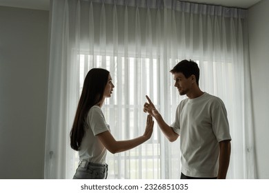 Caucasian unhappy couple having quarreling fight argument with painful. New marriage man and woman crying feel heartbroken for their quarrel conflict in living room. Family problem-separation concept.