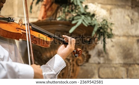 Caucasian violinist man wearing classical clothes and performing in a closed space, church. Live performance. Close up