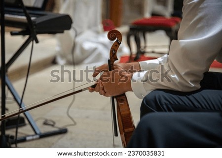 Caucasian violinist man wearing classical clothes and waiting for moment to start musical performance. Concert in an indoor space. Close up