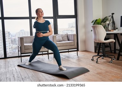 Caucasian Woman With Amputee Arm Stretching While Standing On Yoga Mat