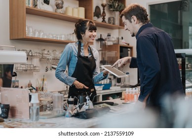 Caucasian woman barista take order from customer in coffee shop. female barista using digital tablet to take order. Coffee owner concept. - Powered by Shutterstock