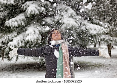 Caucasian Woman Between 30 And 40 Years Old, Dancing In The Snow With A Coat And Scarf. Winter Atmosphere
