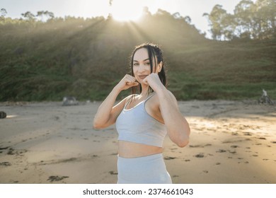 caucasian woman boxing outdoors on the beach - Powered by Shutterstock