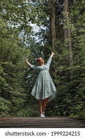 Caucasian Woman Breathing Fresh Air In Forest Raising Her Hands Up. Lifestyle Concept And Active Lifestyle