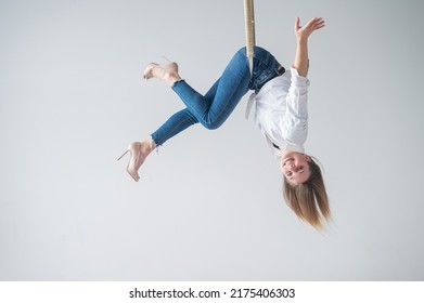 Caucasian woman in casual clothes on an aerial hoop.  - Powered by Shutterstock