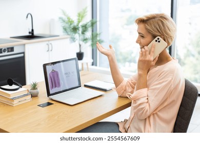 Caucasian woman in casual clothing sitting at desk in bright home environment. She using smartphone to order clothes online and checking laptop screen. Indoor plants and books add to homey atmosphere. - Powered by Shutterstock