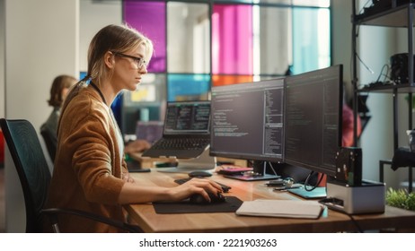 Caucasian Woman Coding on Desktop PC and Laptop Setup With Multiple Displays in Spacious Office. Female Junior Software Engineer Working on New Sprint of Mobile Application Development For Start-up.