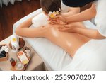 Caucasian woman customer enjoying relaxing anti-stress spa massage and pampering with beauty skin recreation leisure in day light ambient salon spa at luxury resort or hotel. Quiescent