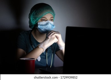 Caucasian Woman Doctor Nurse In Surgical Mask Looks Tired, Exhausted At Night Because Of Covid