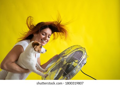 Caucasian Woman And A Dog Are Cooling Off By An Electric Fan