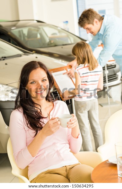 Caucasian woman\
drinking coffee in car retail\
store