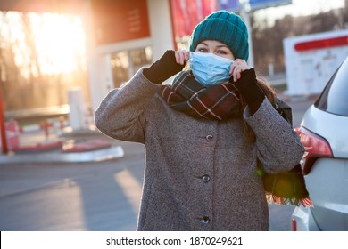 Caucasian Woman A Driver Puts On A Facial Mask Before Refuel A Car And Make Payment On Petrol Station