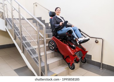 Caucasian woman in electric caterpillar wheelchair climbs up stairs.