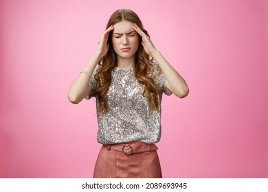 Caucasian woman feeling dizzy drink too much alcohol party, touching temples close eyes frowning suffering headache feeling discomfort, migraine, standing displeased unwell pink background - Shutterstock ID 2089693945