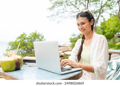 Caucasian woman freelance remote working online corporate business financial on laptop computer at beach cafe. People enjoy outdoor lifestyle travel tropical island on summer beach holiday vacation. - Powered by Shutterstock