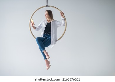 Caucasian Woman Gymnast On An Aerial Hoop Takes A Selfie On A Smartphone. 