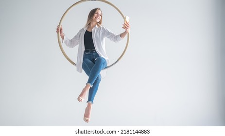 Caucasian Woman Gymnast On An Aerial Hoop Takes A Selfie On A Smartphone. 