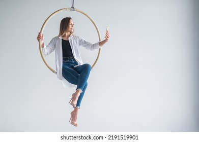 Caucasian Woman Gymnast On An Aerial Hoop Takes A Selfie On A Smartphone. 