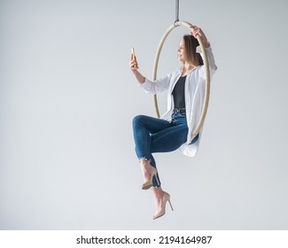 Caucasian Woman Gymnast On An Aerial Hoop Takes A Selfie On A Smartphone. 