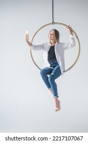 Caucasian Woman Gymnast On An Aerial Hoop Takes A Selfie On A Smartphone. 