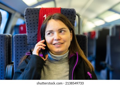 Caucasian Woman Having Telephone Conversation While Sitting Inside Train Carriage.