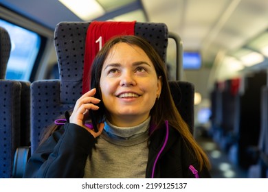 Caucasian Woman Having Telephone Conversation While Sitting Inside Train Carriage.