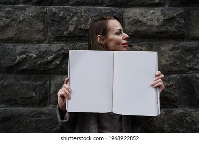 Caucasian Woman Is Holding Beauty Fashion  Magazine With A Blank Pages