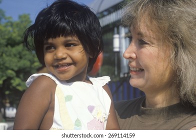 A Caucasian Woman Holding An Indian Child, Chevy Chase, MD