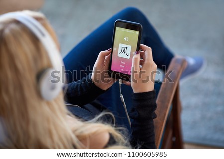 caucasian woman at home learning mandarin chinese on mobile phone language app application
