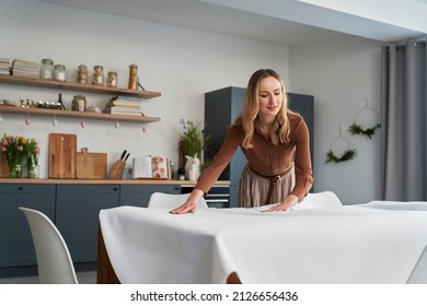 Caucasian woman laying table with a white tablecloth  - Shutterstock ID 2126656436