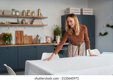 Caucasian woman laying table with a white tablecloth  - Shutterstock ID 2133645971