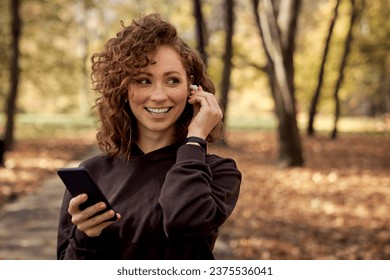 Caucasian woman listening music from mobile phone during the jogging  - Powered by Shutterstock