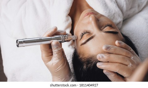 Caucasian woman lying on the couch and having facial anti aging procedures with new technologies at the spa