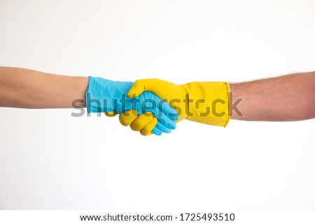 Caucasian woman and man hands and arms in blue and yellow latex gloves shacking hands isolate on white 2020
