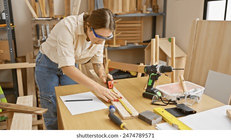 Caucasian woman measuring wood in a carpentry workshop with tools around. - Powered by Shutterstock