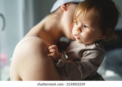 Caucasian Woman Mother Holding His Small Baby Girl While Standing By The Window At Home Looking To The Side Real People Parenthood Bonding Love And Family Concept Copy Space