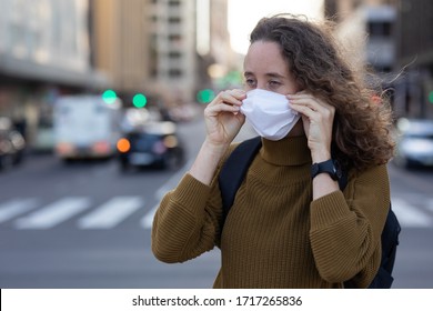  Caucasian Woman Out And About In The City Streets During The Day, Putting On A Face Mask Against Covid19 Coronavirus