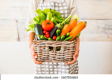 Caucasian woman people with bucket full of coloured and mixed fresh healthy food like fruit and vegetables - concept of little store with km 0 products