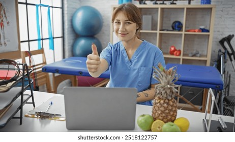 Caucasian woman physiotherapist giving thumbs up in clinic with laptop and fruits on desk - Powered by Shutterstock