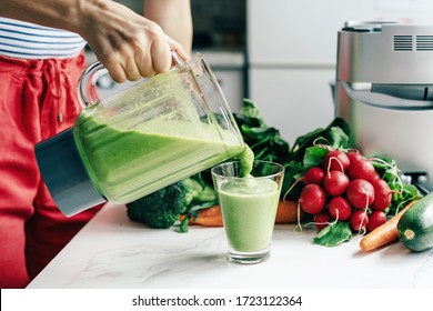 .Caucasian woman pours smoothie into a glass. Vegetable drink. Healthy eating concept. Monitor your health and nutrition. - Powered by Shutterstock