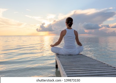 Caucasian woman practicing yoga at seashore - Powered by Shutterstock